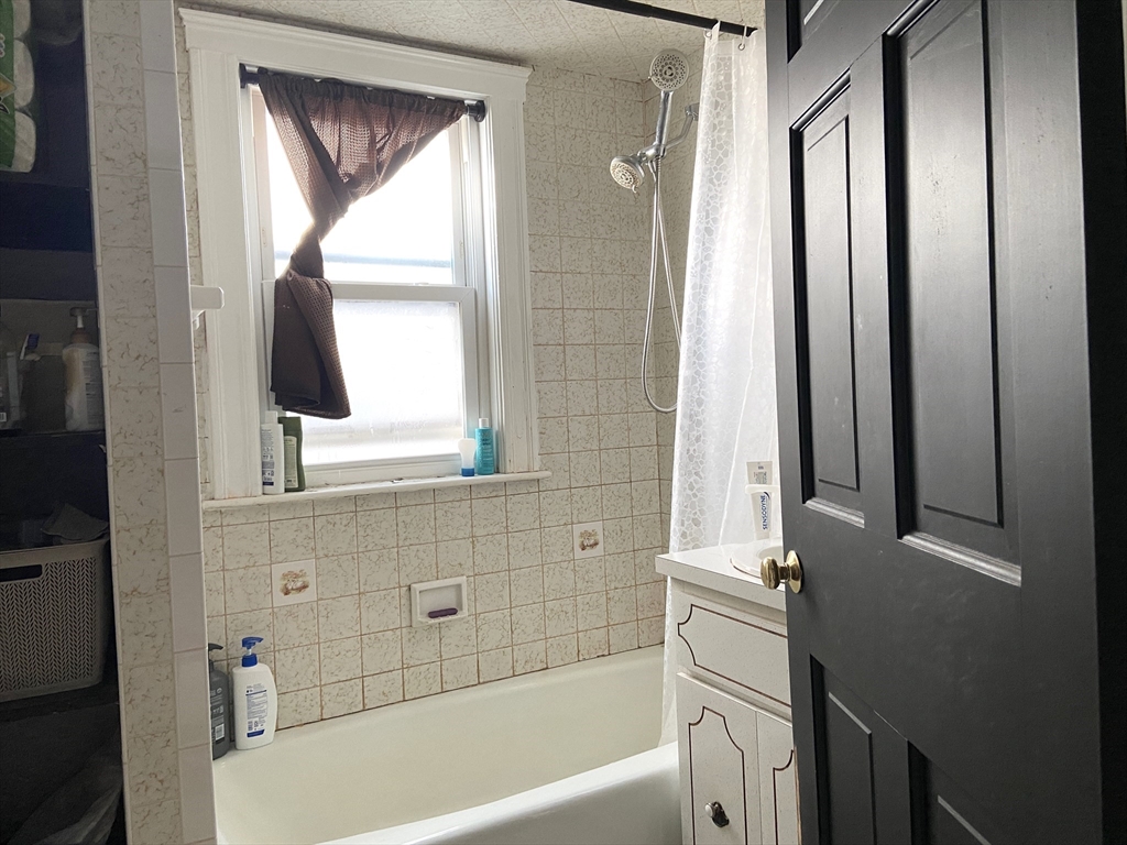 26 Harrison Street, Unit 1 Quincy, MA 02169 - Photo 9 of 14 a bathroom with a bathtub and a sink