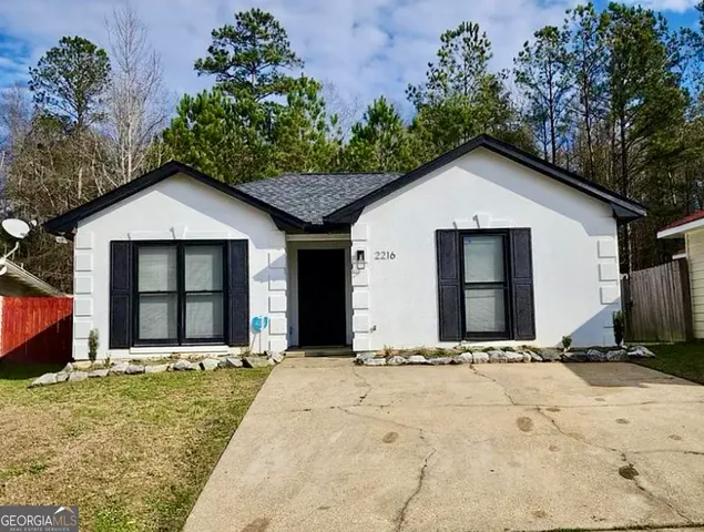 a front view of a house with a yard and trees