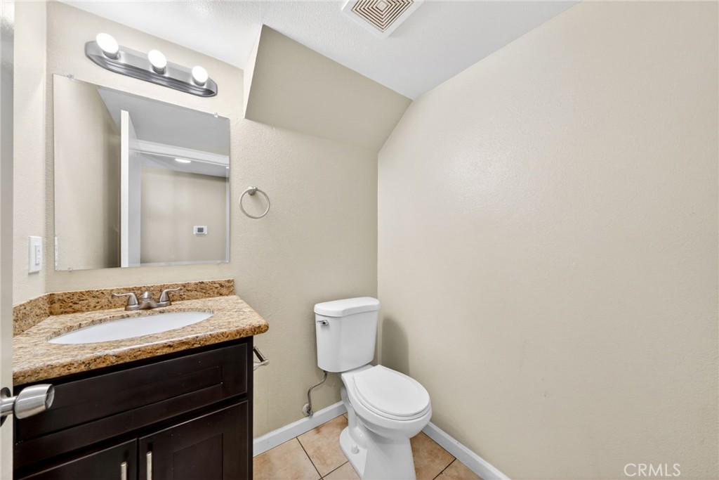 14380 Foothill Boulevard Sylmar, CA 91342 - Photo 12 of 27 a bathroom with a granite countertop sink and a toilet