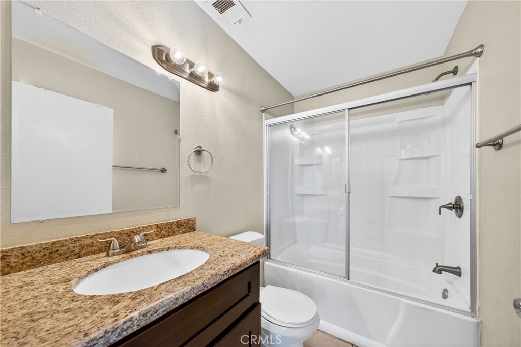 14380 Foothill Boulevard Sylmar, CA 91342 - Photo 21 of 27 a bathroom with a granite countertop sink toilet mirror and shower