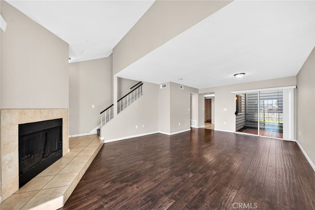 14380 Foothill Boulevard Sylmar, CA 91342 - Photo 4 of 27 a view of an empty room with wooden floor fireplace and a window