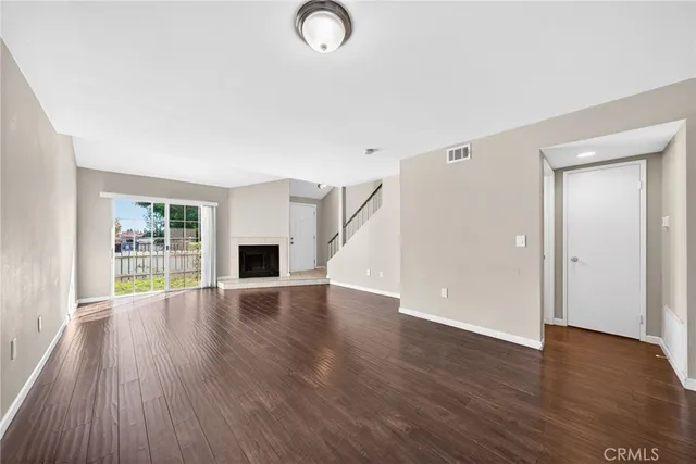 an empty room with wooden floor and fireplace
