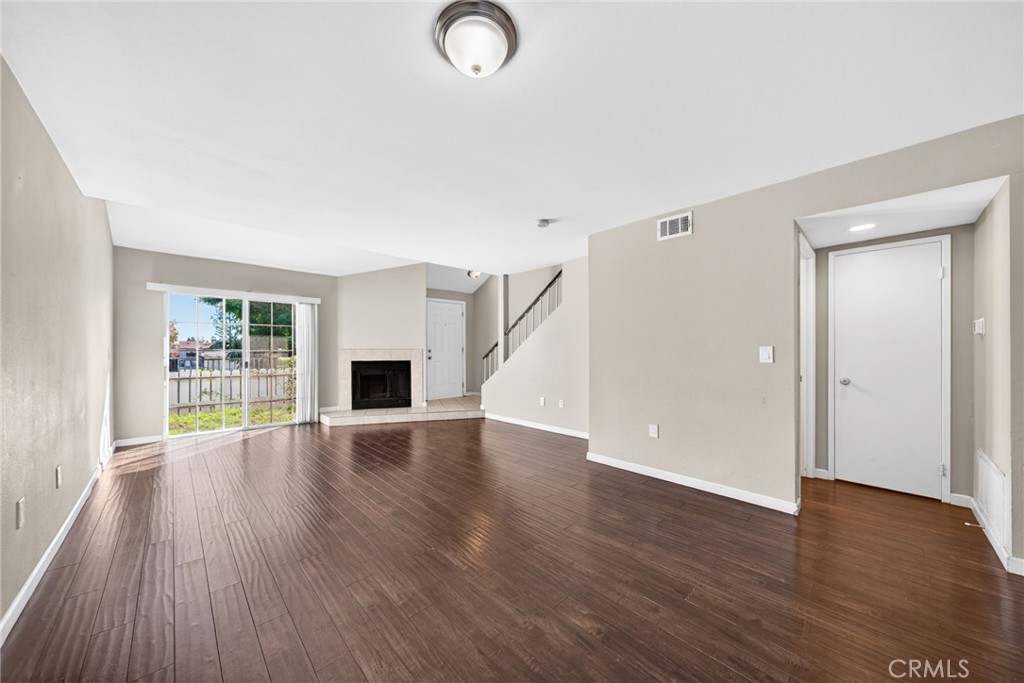 14380 Foothill Boulevard Sylmar, CA 91342 - Photo 5 of 27 an empty room with wooden floor and fireplace
