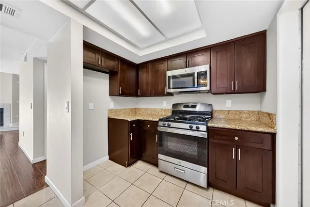 a kitchen with granite countertop wooden cabinets and stainless steel appliances
