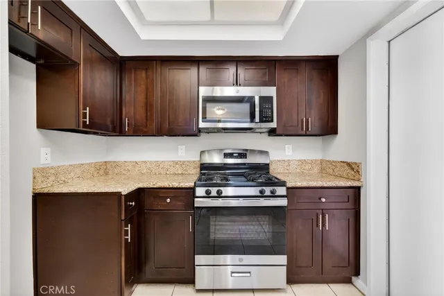 a kitchen with granite countertop wooden cabinets and stainless steel appliances