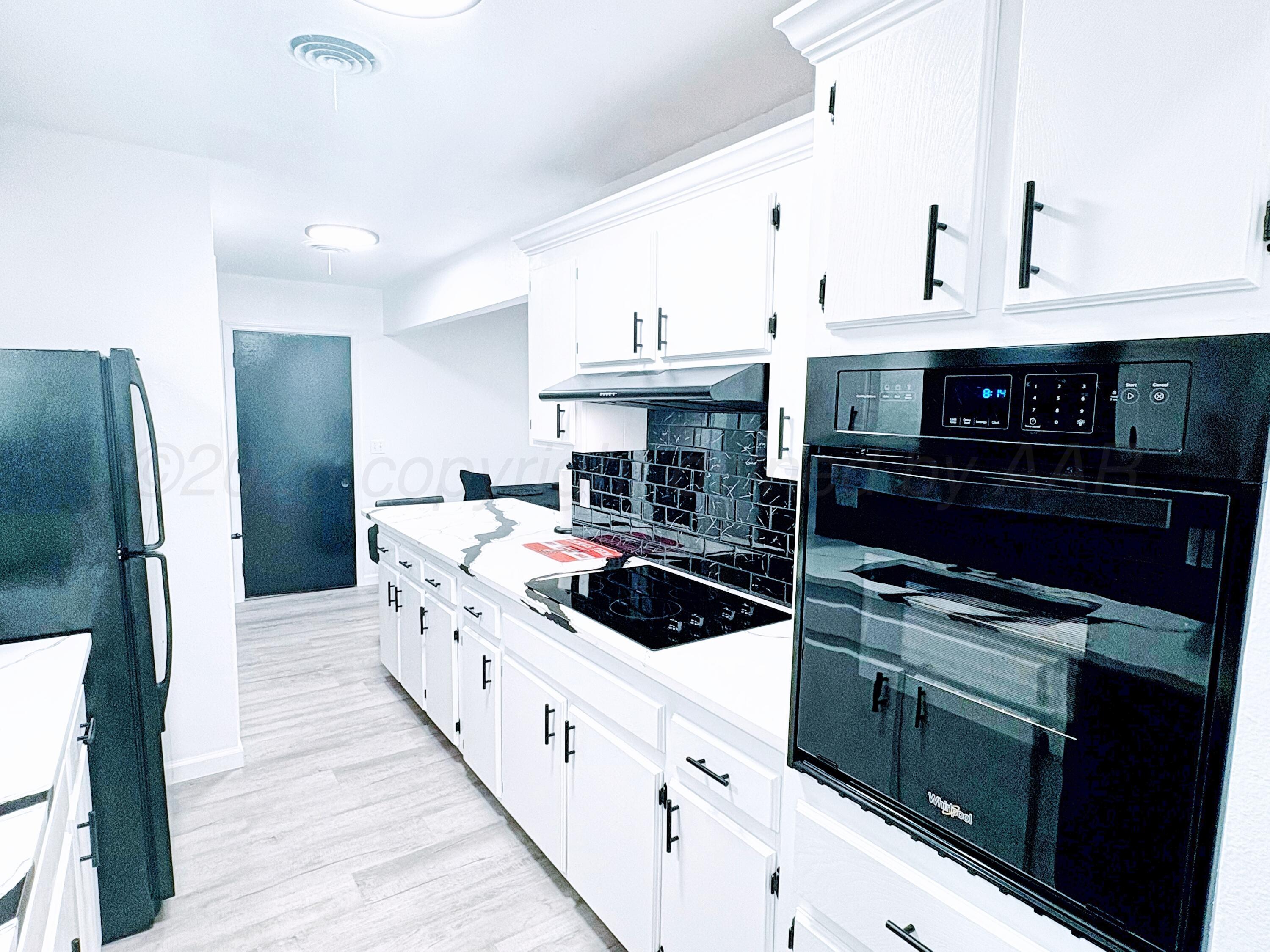 2310 Texas Street Perryton, TX 79070 - Photo 11 of 26 a kitchen with stainless steel appliances granite countertop a sink a stove and a refrigerator