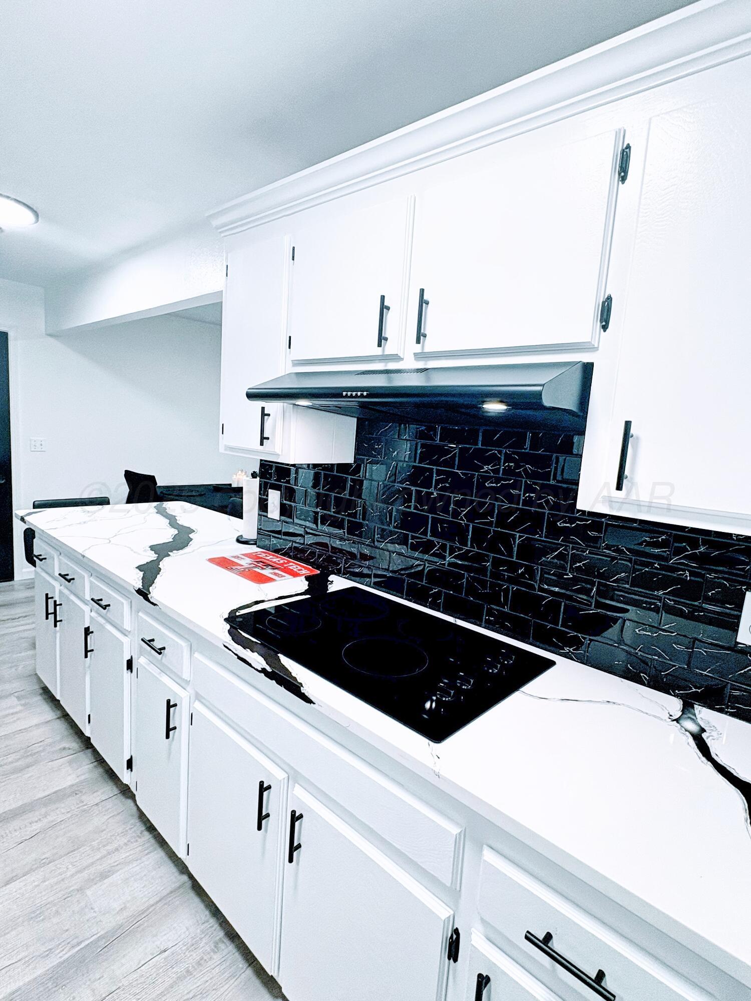 2310 Texas Street Perryton, TX 79070 - Photo 12 of 26 a kitchen with a sink a stove and cabinets