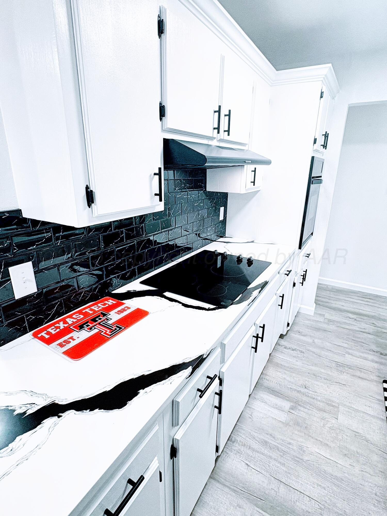 2310 Texas Street Perryton, TX 79070 - Photo 13 of 26 a kitchen with granite countertop a sink and a stove
