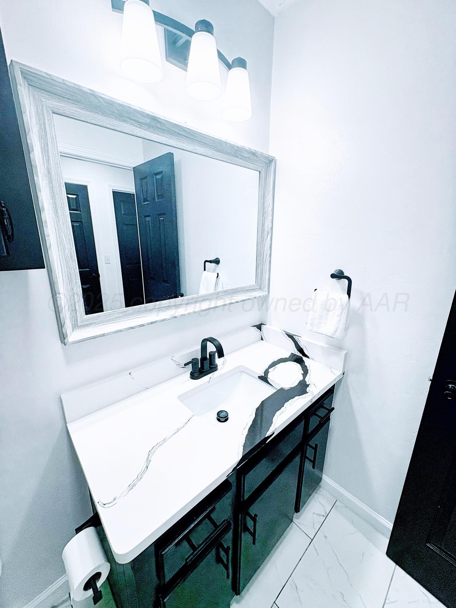 2310 Texas Street Perryton, TX 79070 - Photo 23 of 26 a bathroom with a sink and a mirror