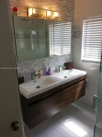 a bathroom with a sink vanity and a mirror