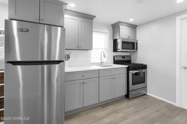 a kitchen with white cabinets and stainless steel appliances