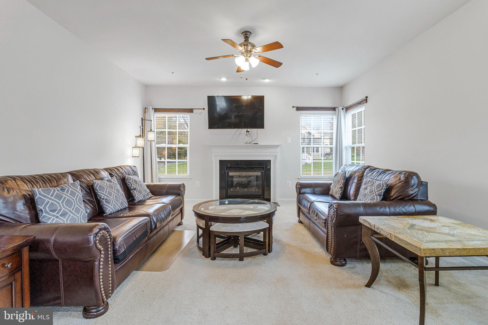 4615 Cimmaron Greenfields Drive Bowie, MD 20720 - Photo 10 of 27 a living room with furniture a flat screen tv and a fireplace
