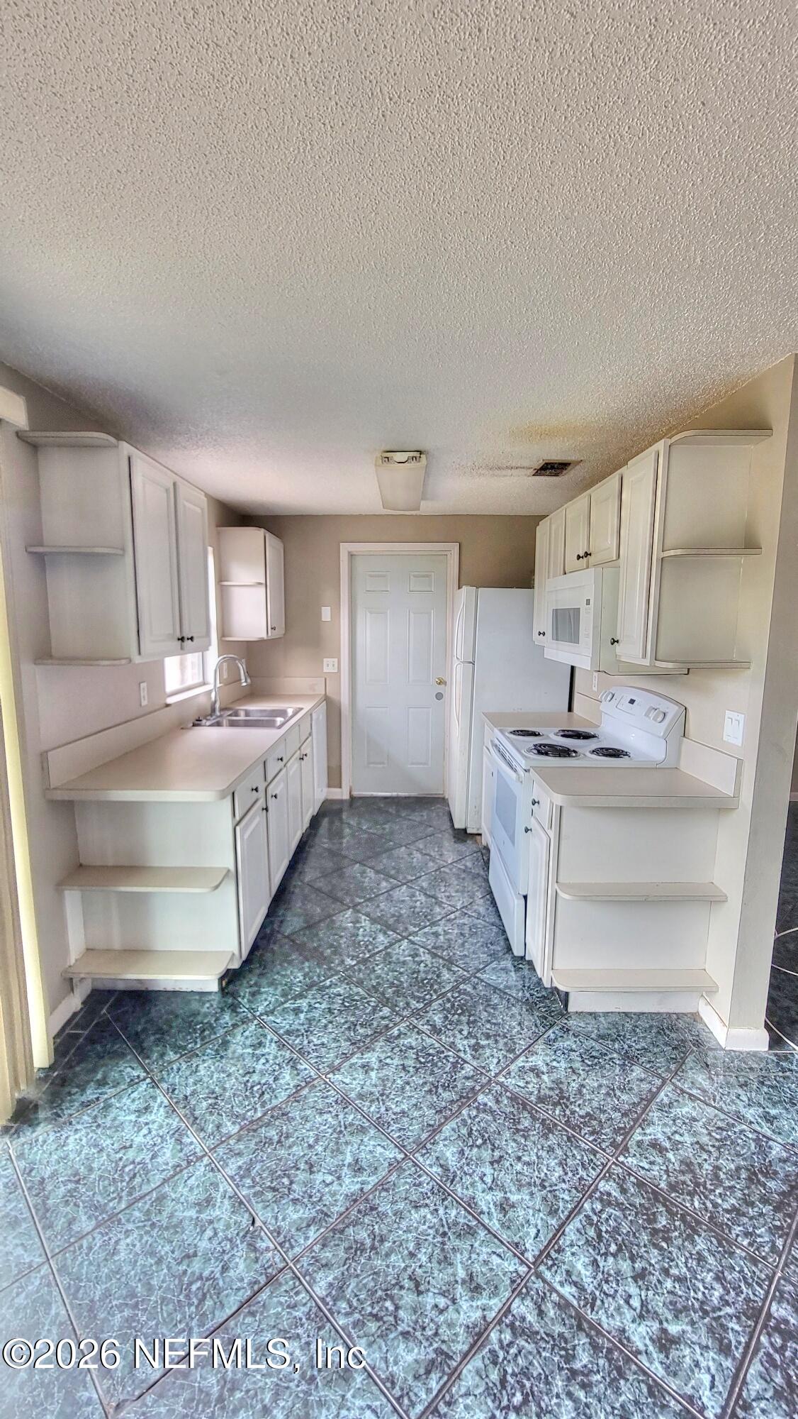 2472 Fernside Road Jacksonville, FL 32246 - Photo 7 of 16 a room with kitchen island a sink large mirror and cabinets