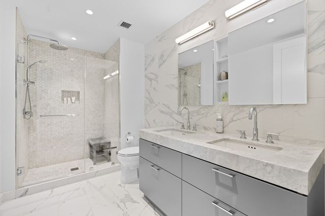 a bathroom with a sink double vanity mirror and a shower