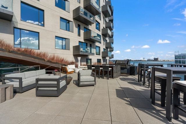a view of a patio with couches table and chairs under an umbrella