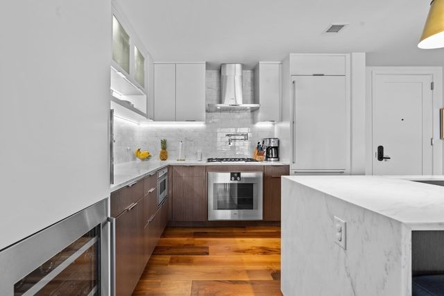 a kitchen with kitchen island granite countertop a sink stove and cabinets