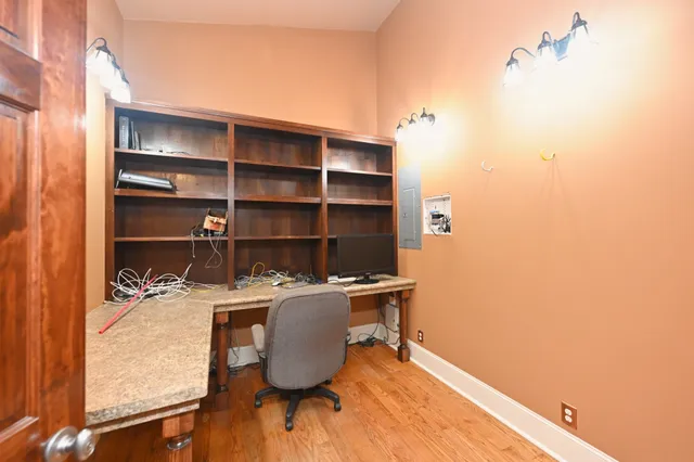 a view of a big room with wooden floor chandelier and windows