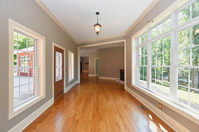 a view of a hallway with wooden floor and a cabinet