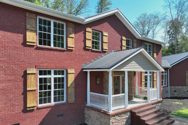 a front view of a house with a yard and trees