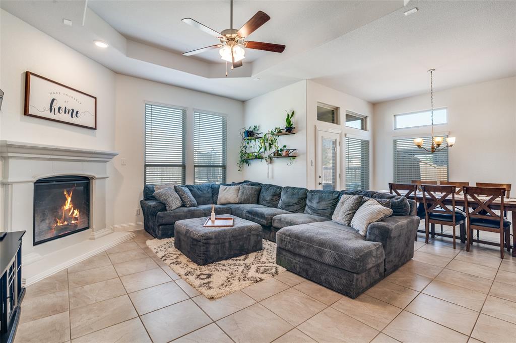 537 Declaration Way Fate, TX 75189 - Photo 2 of 39 a living room with furniture a fireplace and a chandelier