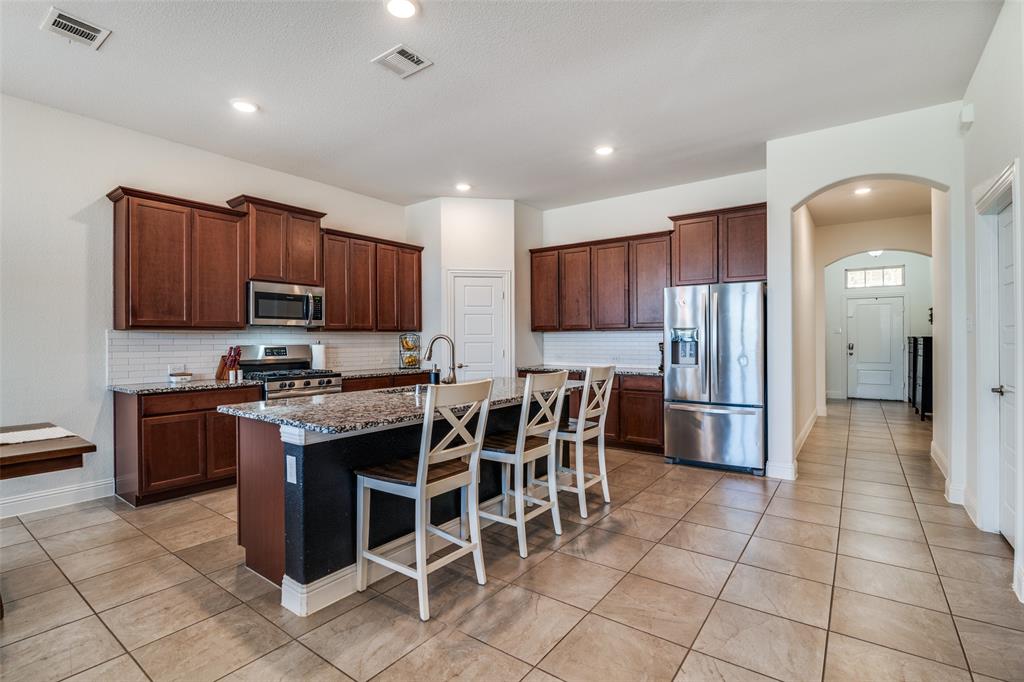 537 Declaration Way Fate, TX 75189 - Photo 3 of 39 a kitchen with stainless steel appliances granite countertop a stove top oven a sink a refrigerator and a microwave