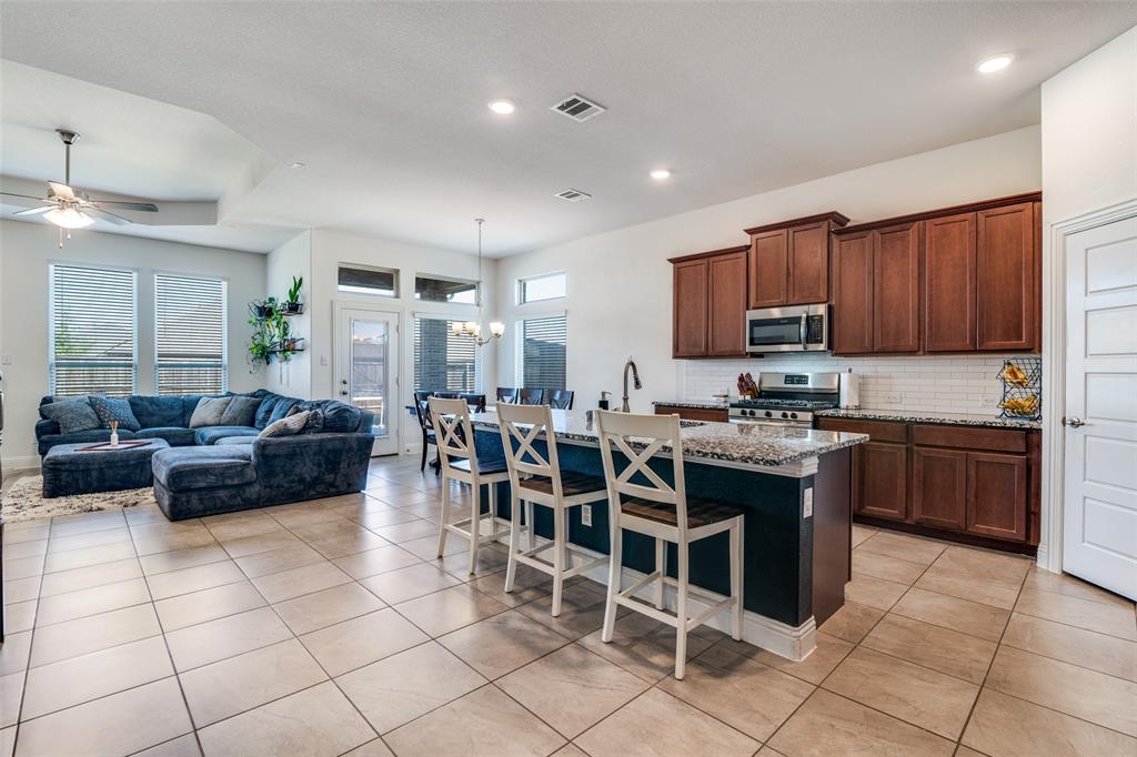 537 Declaration Way Fate, TX 75189 - Photo 6 of 39 a kitchen with stainless steel appliances granite countertop a stove a sink a microwave and a dining table