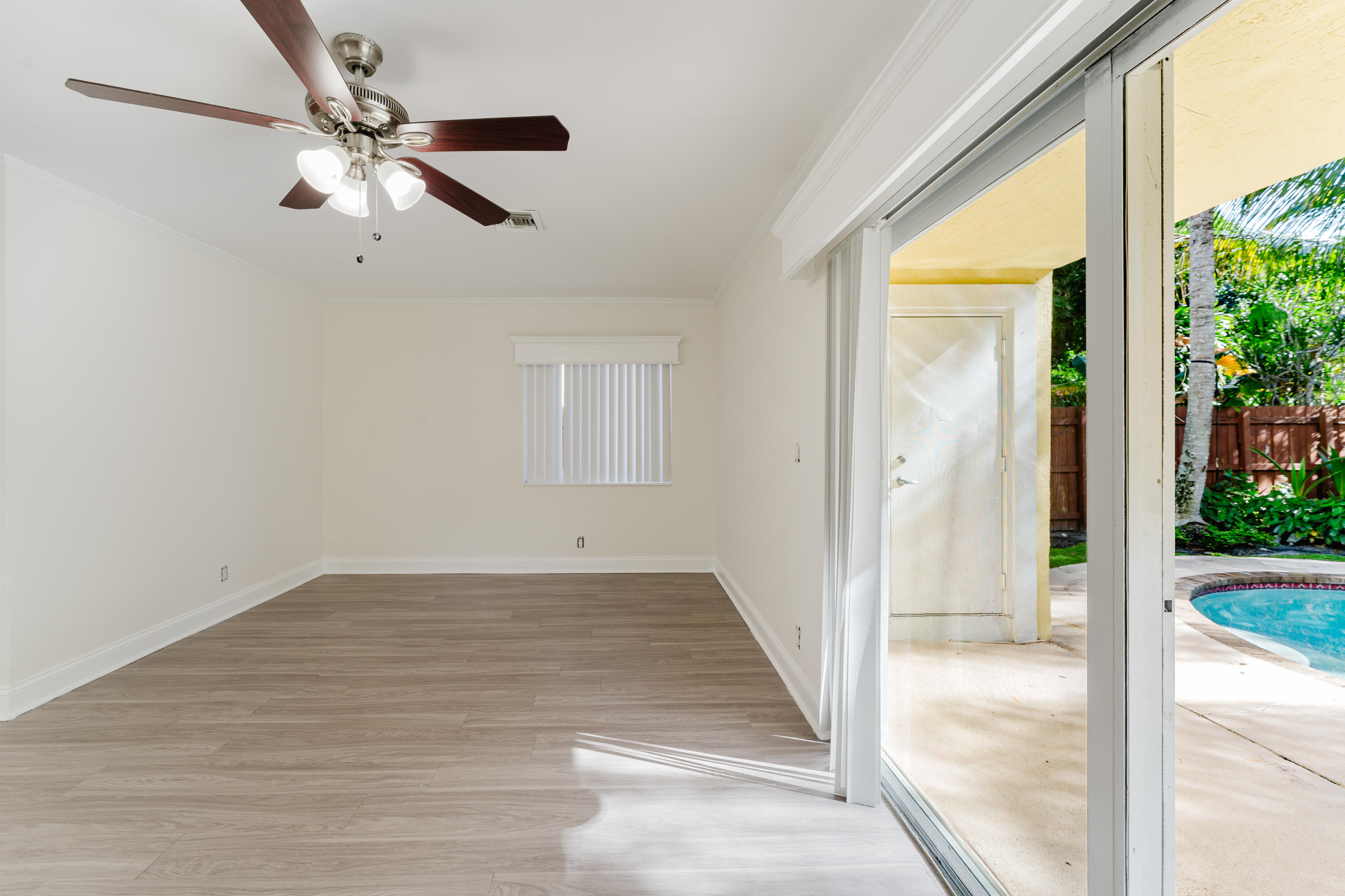 302 Northeast 36th Street Boca Raton, FL 33431 - Photo 17 of 40 an empty room with wooden floor fan and windows
