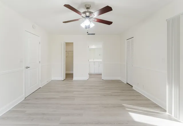 a view of an empty room with a chandelier fan