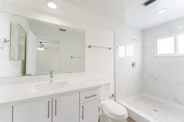 a bathroom with a sink a toilet and shower