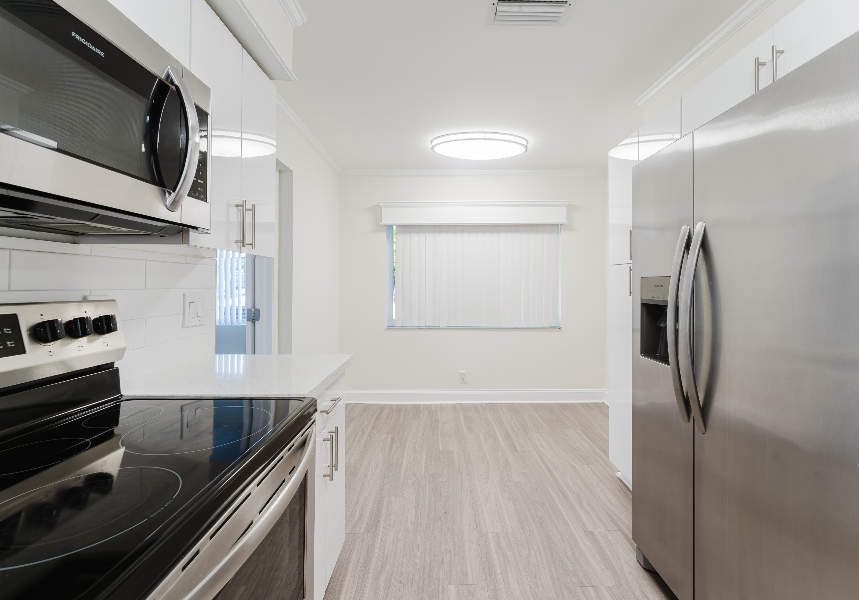 302 Northeast 36th Street Boca Raton, FL 33431 - Photo 9 of 40 a kitchen with a refrigerator and a sink