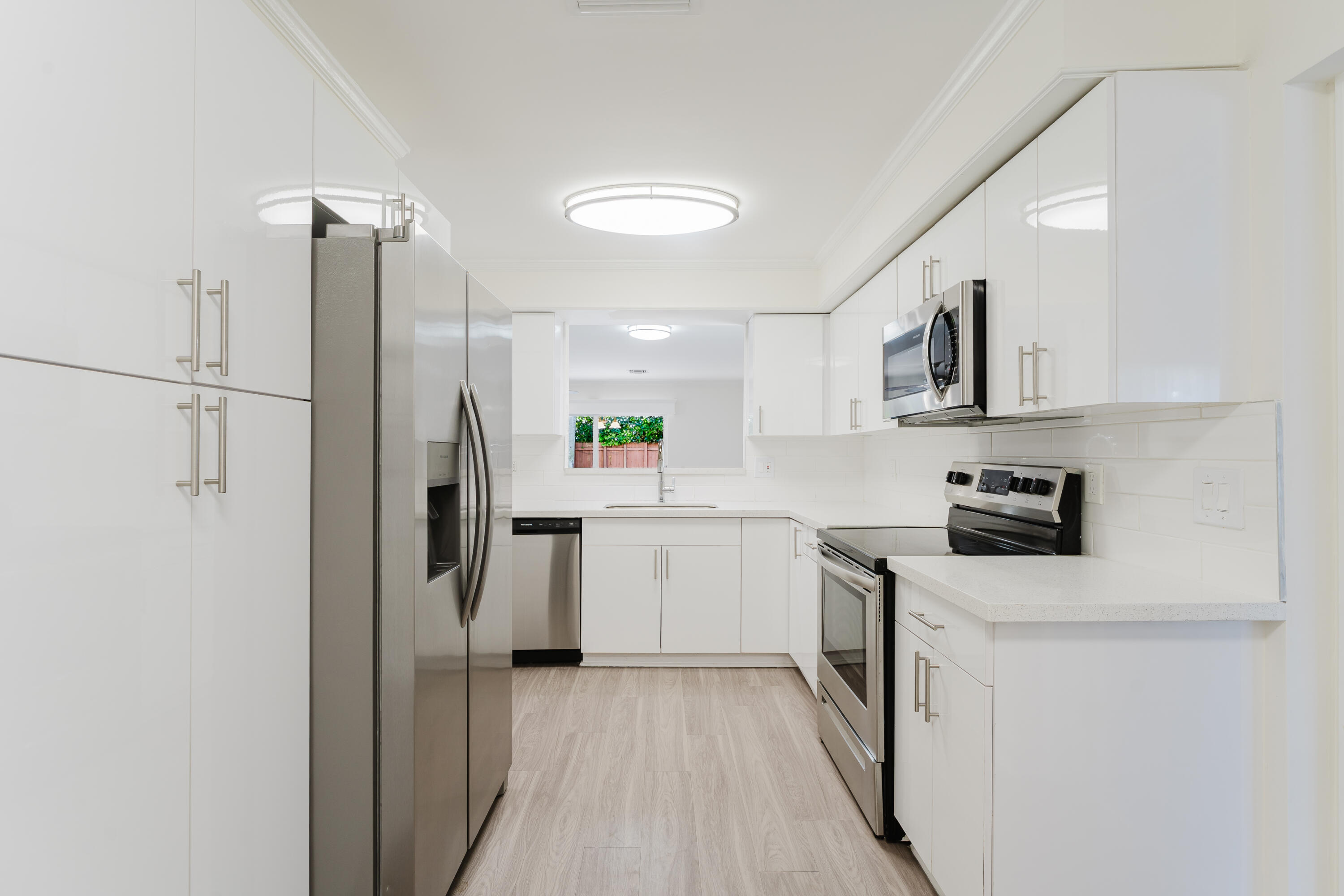 302 Northeast 36th Street Boca Raton, FL 33431 - Photo 10 of 40 a kitchen with a refrigerator a sink and dishwasher