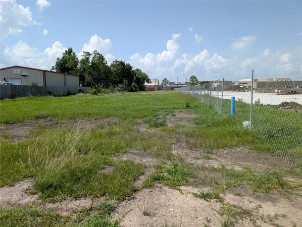 a view of a green field with wooden fence