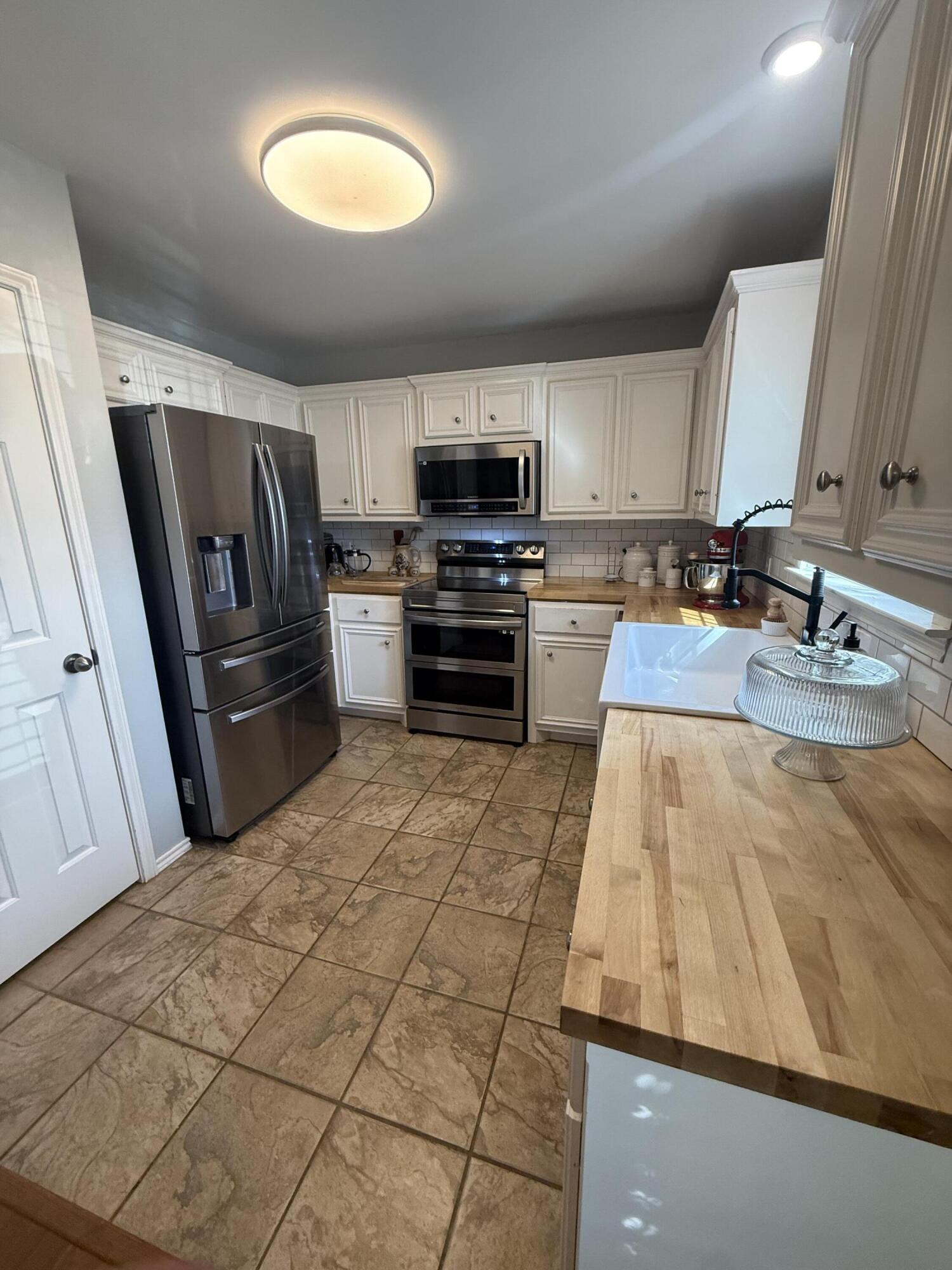 6906 8th Street Lubbock, TX 79416 - Photo 13 of 42 a kitchen with kitchen island a counter top space cabinets and stainless steel appliances