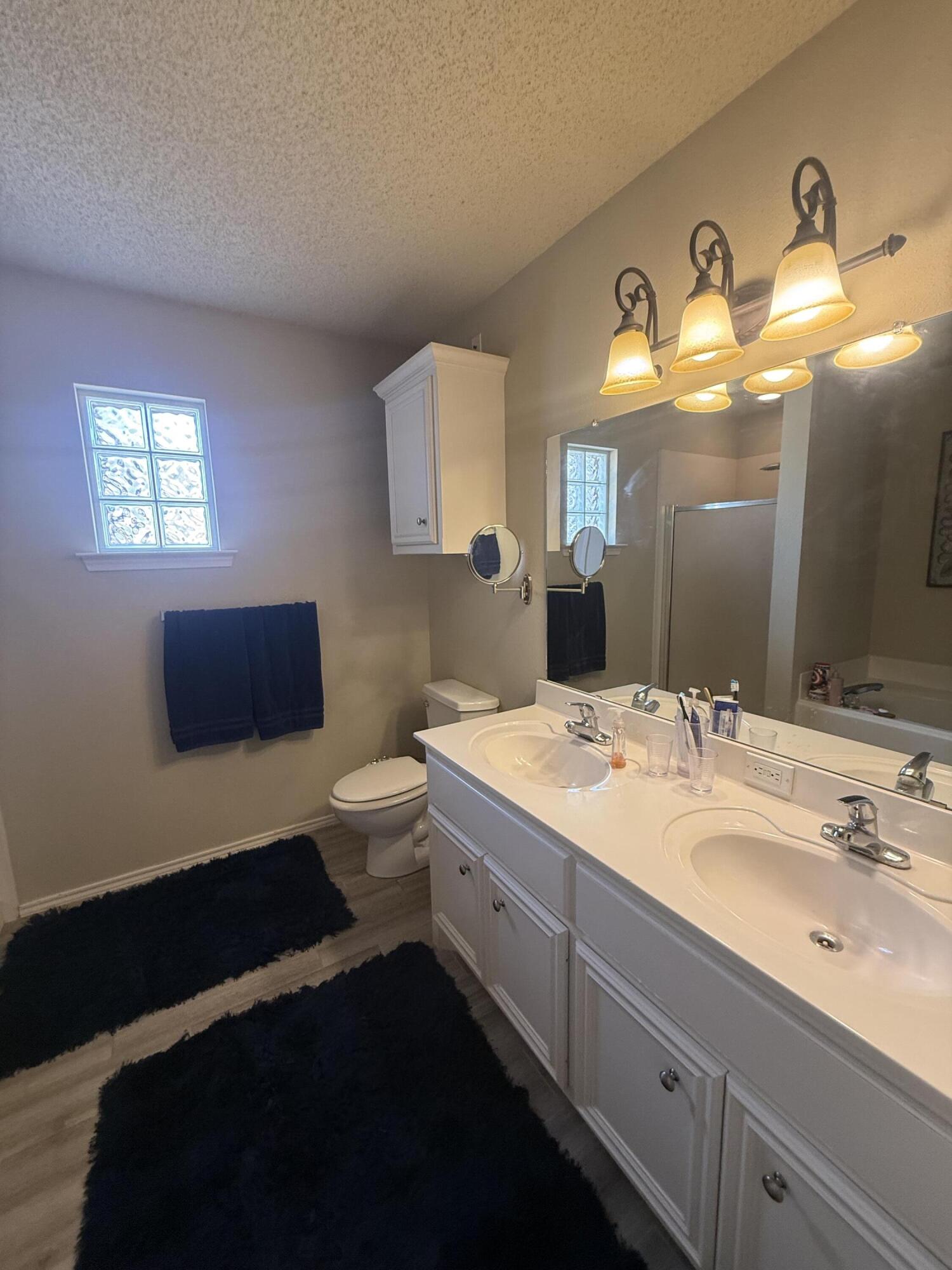 6906 8th Street Lubbock, TX 79416 - Photo 23 of 42 a bathroom with a sink and a mirror