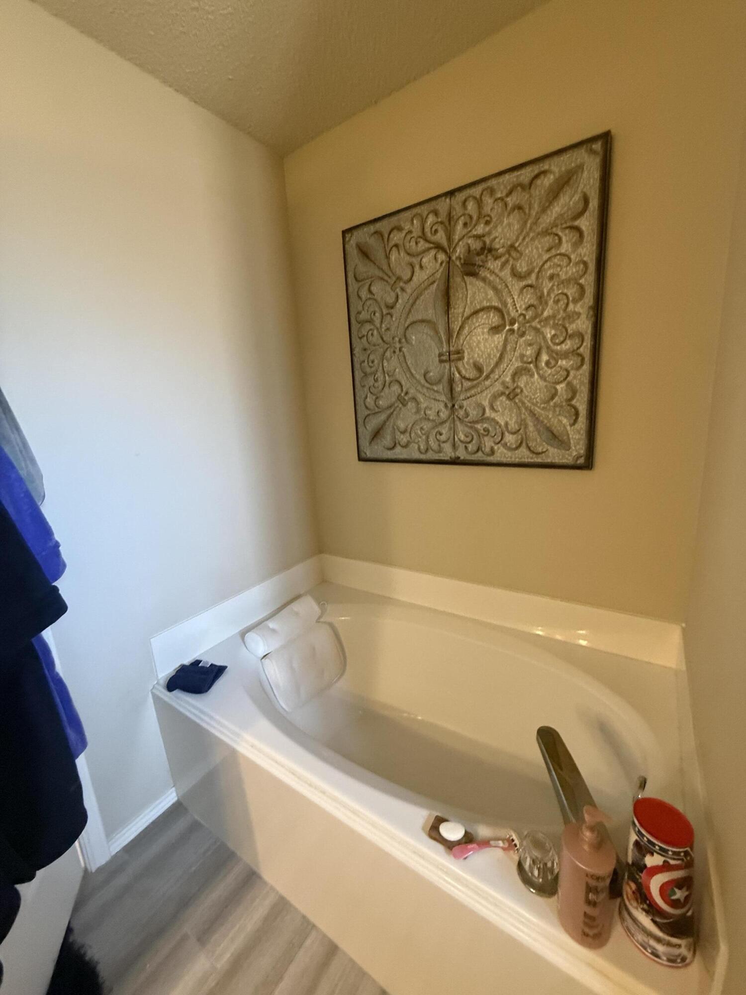 6906 8th Street Lubbock, TX 79416 - Photo 24 of 42 a bath tub sitting next to a white sink and vanity