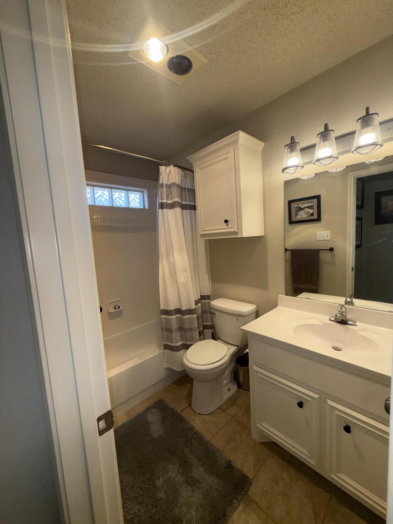6906 8th Street Lubbock, TX 79416 - Photo 29 of 42 a bathroom with a sink a toilet and shower