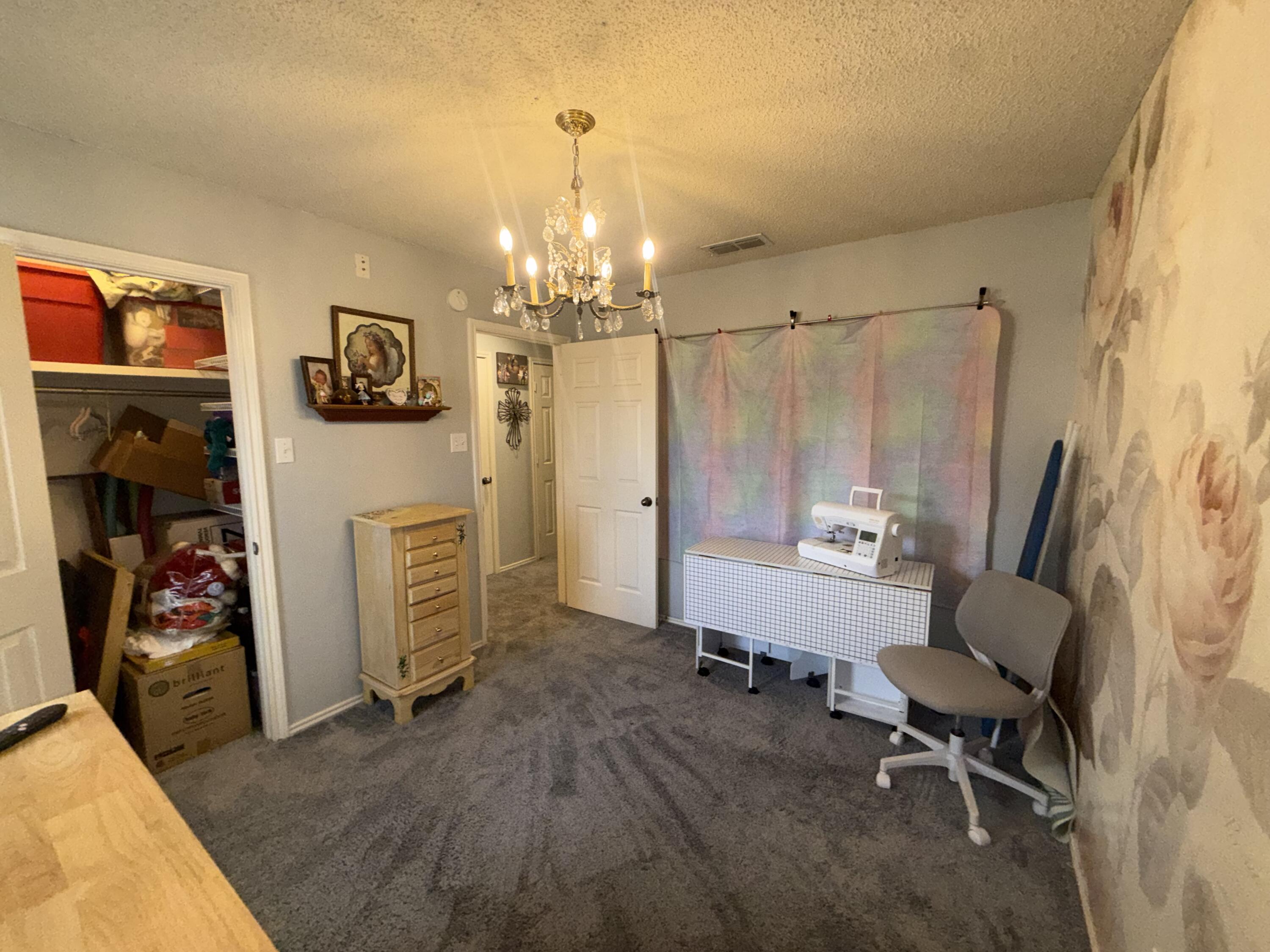 6906 8th Street Lubbock, TX 79416 - Photo 33 of 42 a spacious bedroom with a bed and a chair