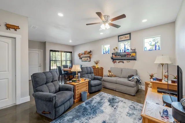 a living room with furniture ceiling fan and a window