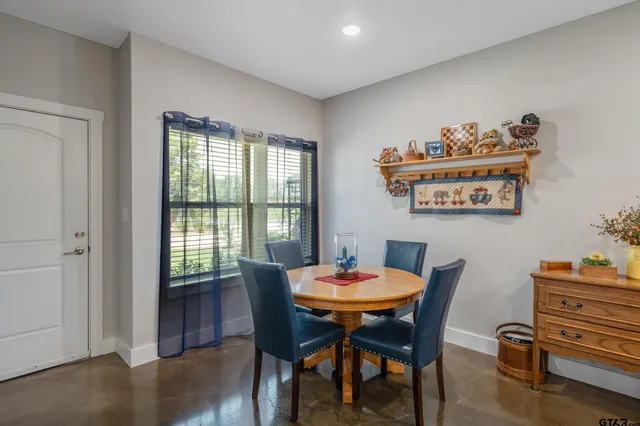 a dining room with furniture a rug and a window