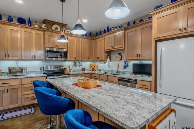 a kitchen with stainless steel appliances granite countertop a sink a stove and a refrigerator