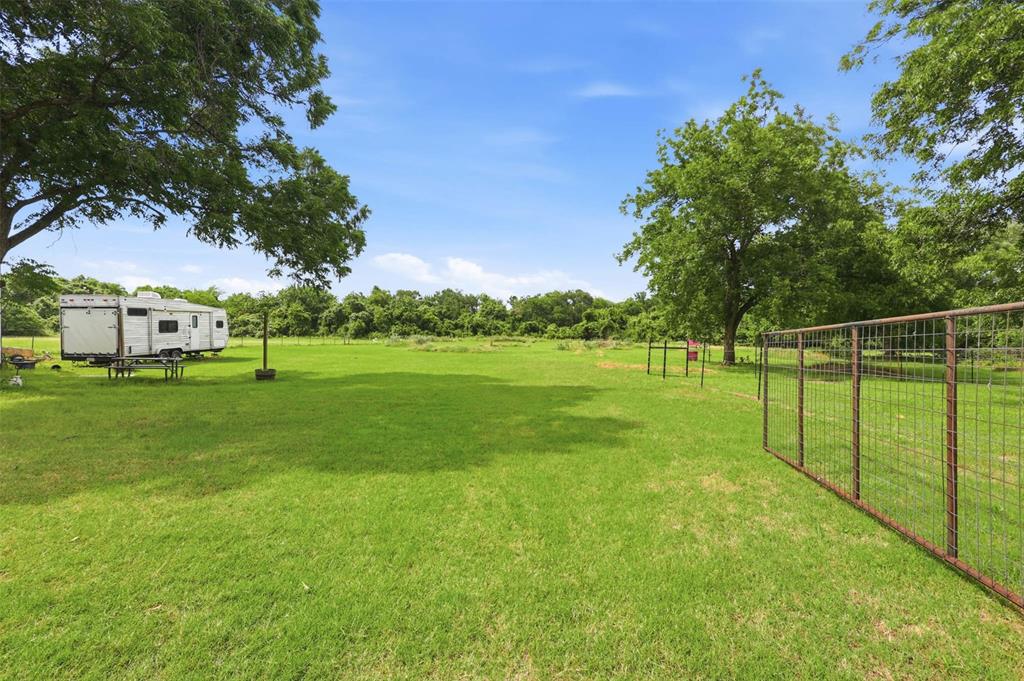 308 West 1st Street Springtown, TX 76082 - Photo 31 of 39 Expansive green space featuring scattered mature trees and a partial wire fence