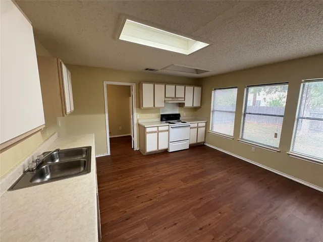 a kitchen with stainless steel appliances granite countertop a sink stove and wooden floor