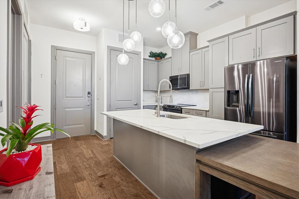 2700 Old Denton Road, Unit 3346 Carrollton, TX 75007 - Photo 3 of 21 a kitchen with a refrigerator a sink and cabinets
