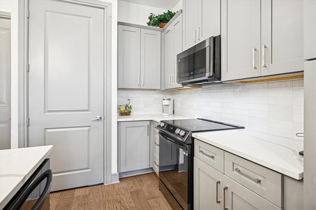 2700 Old Denton Road, Unit 3346 Carrollton, TX 75007 - Photo 5 of 21 a kitchen with white cabinets and stainless steel appliances