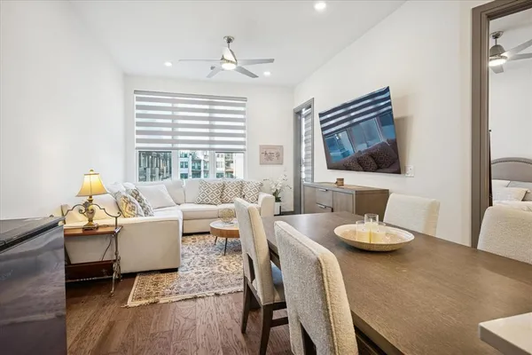 a living room with furniture flat screen tv and wooden floor