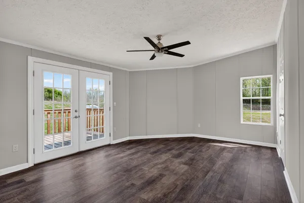 an empty room with wooden floor and windows