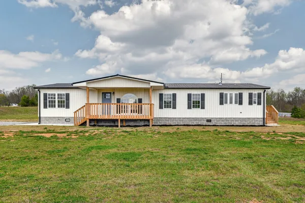 a white house sitting in middle of the grass