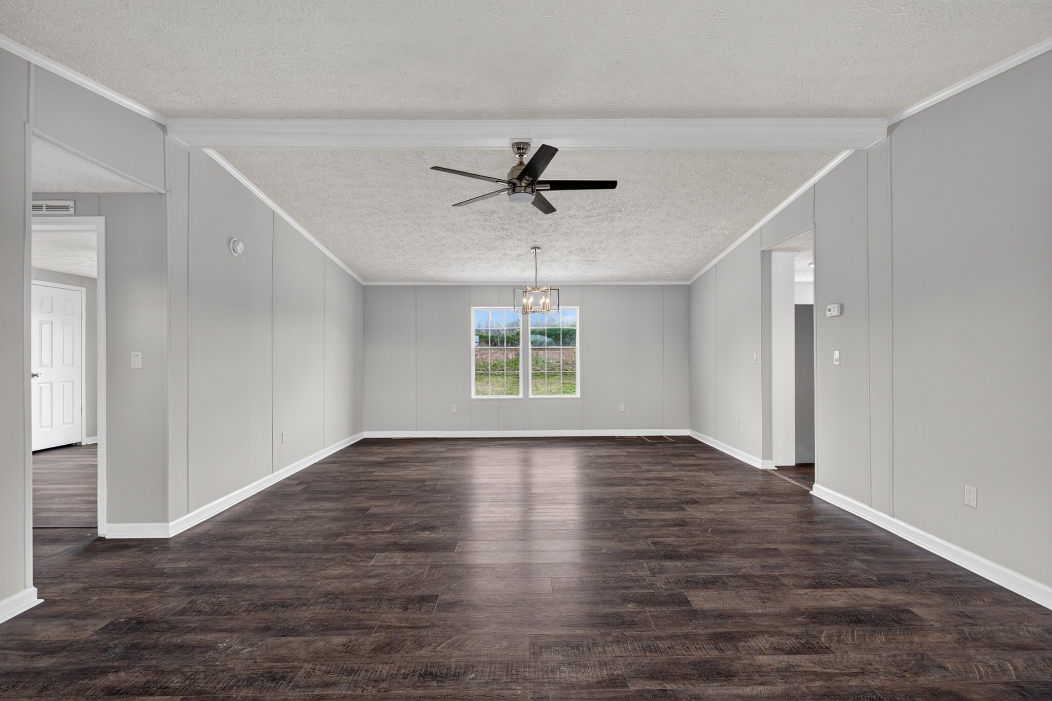560 Old Huntsville Road Fayetteville, TN 37334 - Photo 7 of 32 an empty room with wooden floor chandelier fan and windows