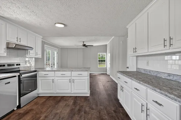 a kitchen with granite countertop white cabinets and white appliances