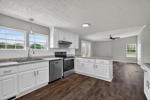 a kitchen with granite countertop white cabinets and white appliances